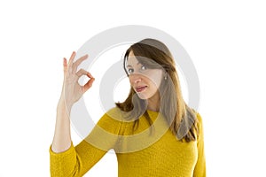 Portrait of pretty smiling woman showing ok sign isolated on white background