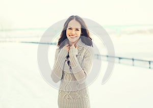 Portrait pretty smiling woman wearing a knitted sweater outdoors in winter