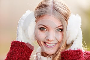 Portrait of pretty smiling woman in white earmuffs.