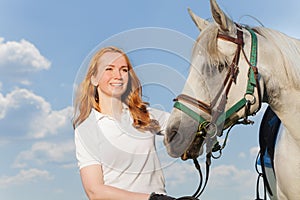 Portrait of pretty smiling woman with white horse