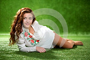 Portrait of pretty smiling young woman, laying on the grass, nat