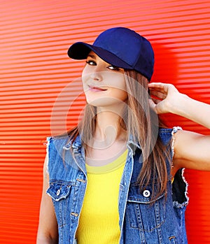 Portrait of pretty stylish young girl wearing a cap and jeans