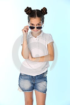 Portrait of a pretty teenage girl 12 years old in a denim shorts with bare legs, she is looking cool