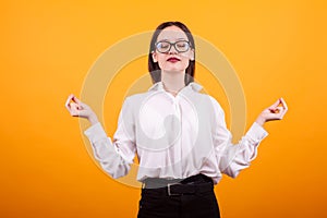 Portrait pretty teenage girl meditate in studio over yellow background