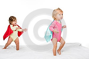 portrait of pretty toddler girls in superhero capes