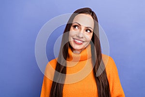 Portrait of pretty woman brown hair wearing orange pullover looking empty space at winter sale clothes isolated on