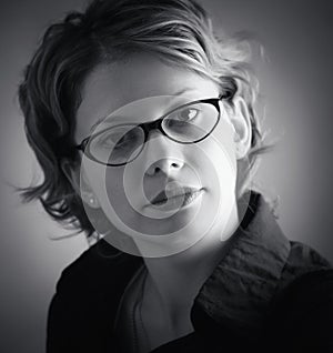 Portrait of pretty woman in glasses over black