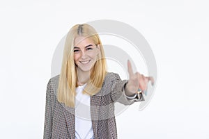 Portrait of a pretty woman pointing finger away on a white background