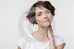 Portrait of pretty woman with short brown hair in basic t-shirt looking at camera