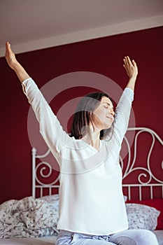 Portrait of pretty woman stretching in bed after wake up