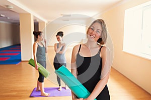 Portrait of pretty woman in yoga class. Group of young women on the background. Tint