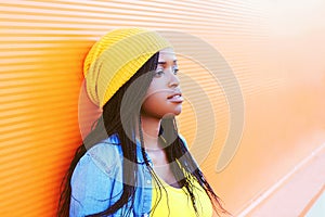 Portrait pretty young african woman over orange background