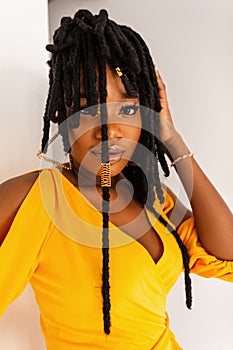 Portrait pretty young afro woman with clean healthy skin with lips in beautiful fashion yellow summer dress with hairstyle.