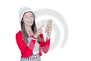 Portrait of pretty young Asian teen girl wearing red dress and white hat happily smile using smartphone while working isolated on