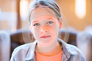 Portrait of pretty young girl smiling with closed mouth sitting