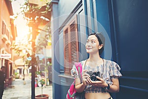 Portrait of pretty young hipster woman having fun in the city with camera taveling taking