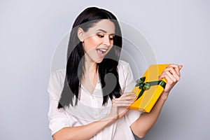 Portrait of pretty young laughing woman holding present because of her birthday