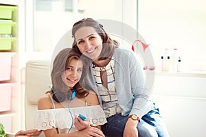 Portrait of pretty young mother with her tennager daughter