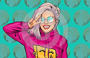Portrait of pretty young smiling woman showing V sign dressed trendy in comic style.