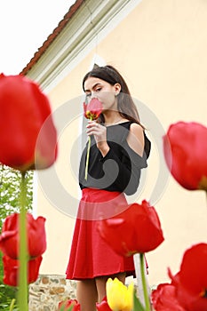 Portrait of pretty young teen girl among red tulips