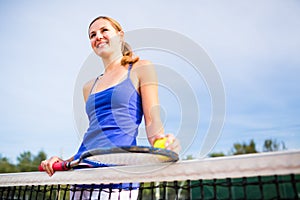 Portrait of a pretty, young tennis player  on  a court