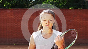 Portrait of pretty young tennis playgirl with racket smiling and going at camera