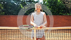 Portrait of pretty young tennis playgirl standing with racket. photo