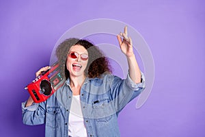 Portrait of pretty young woman carry boombox empty space wear denim shirt isolated on purple color background