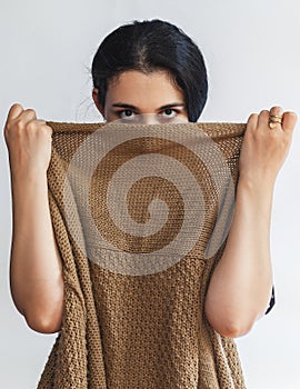 Portrait of a pretty young woman hiding her face under clothes. Attractive Muslim girl hiding face under clothes and looking