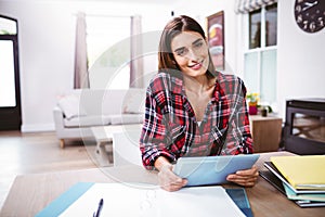 Portrait of pretty young woman holding digital tablet