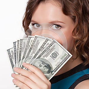 Portrait of pretty young woman holding a fan of dollar bills