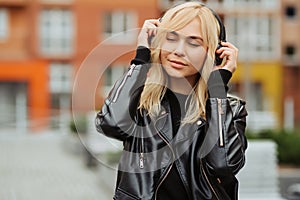 Portrait of pretty young woman listening to music with wireless headphones