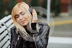 Portrait of pretty young woman listening to music with wireless headphones while