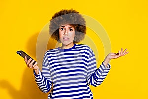 Portrait of pretty young woman smart phone shrug shoulder wear striped shirt isolated on yellow color background