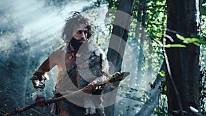 Portrait of Primeval Caveman Wearing Animal Skin and Fur Hunting with a Stone Tipped Spear in the