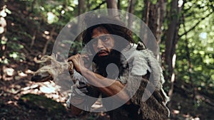 Portrait of Primeval Caveman Wearing Animal Skin and Fur Hunting with a Stone Tipped Spear in the