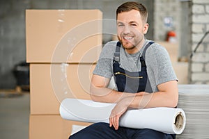 Portrait of production line worker controlling manufacturing process of modern packaging industrial machine in printing