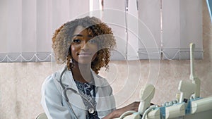 Portrait of professional african american female doctor with ultrasound device in modern clinic