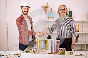 Portrait of professional architect and builder shaking hands