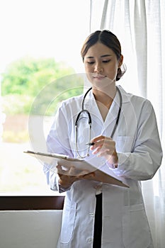 Portrait, Professional Asian female doctor holding a medical clipboard