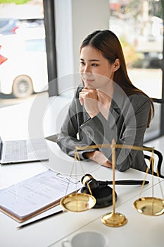 Portrait, Professional Asian female lawyer or legal advisor sitting at her office desk