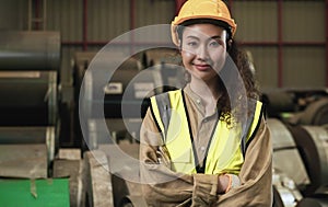 Portrait of professional Asian woman worker standing smiling arms crossed and looking on camera in factory warehouse