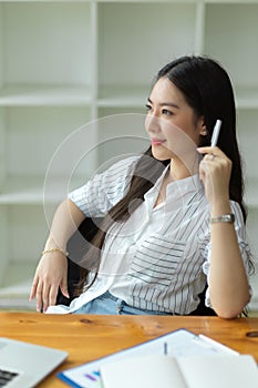 Portrait of professional businesswoman looking out window, thinking creative business idea