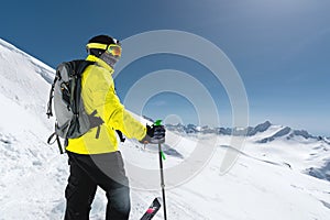 Portrait of a professional freerider skier standing on a snowy slope against the background of snow-capped mountains