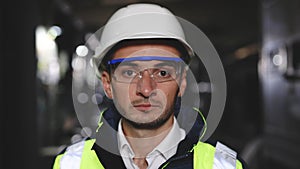 Portrait of Professional Heavy Industry Engineer or Worker Wearing Safety Uniform, Goggles and Hard Hat Looks at Camera