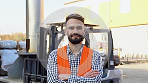 Portrait of professional heavy industry worker wearing uniform against the background of the warehouse loader