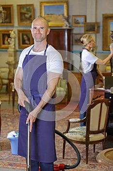 Portrait professional male cleaner holding vacuum