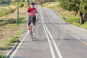 Portrait of Professional Male Cyclist Doing Uphill on Road Bike.