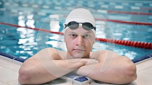 Portrait of professional male swimmer in goggles emerging from swimming pool