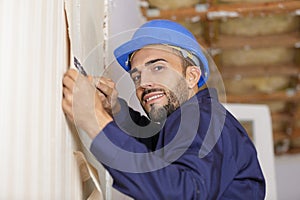 portrait professional man stripping wallpaper with scraper